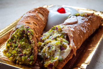 Homemade sweet cannoli stuffed with ricotta cream and Sicilian pistachio dessert. Italian Sicilian pastry.

