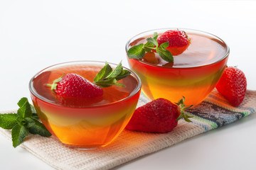 Fruit jelly with strawberries on a white table