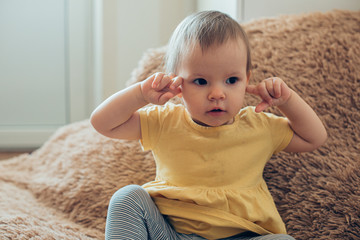 Lovely little girl looking away and touching her ears stock photo