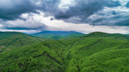 Spring landscape in mountains and the dark blue sky with clouds. A drone shot.