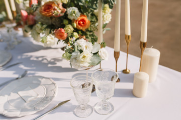 Wedding decoration table in the garden, floral arrangement, In the style vintage & rustic on outdoor. Decorated white table with yellow flowers, served for two people. Fine art laying. Family romantic