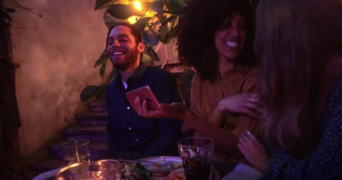 Close up black woman showing video on smartphone to friends