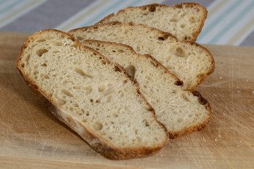 Sliced freshly baked homemade sourdough bread on a wooden board