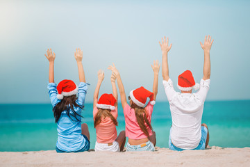 Happy family with two kids in Santa Hat on summer vacation