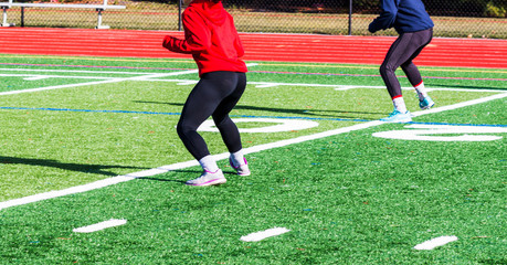 Athletes doing warm up bounding drills on turf field