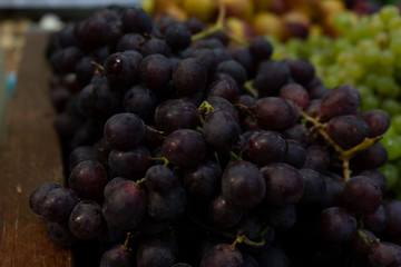 Black grapes on a store counter.