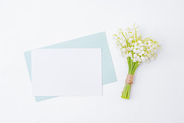 Mockup white wedding invitation and envelope with white flowers on a white background