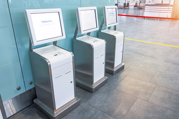Three self check-in counters for a flight located in the airport passenger terminal, convenience and time saving.