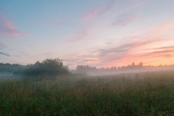 Naklejka na ściany i meble Magnificent sunset and mist spreading across the field, Leningrad region, Russia