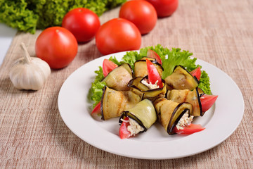 rolls of grilled slices of eggplant with feta cheese and tomato