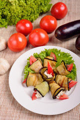 rolls of grilled slices of eggplant with feta cheese and tomato