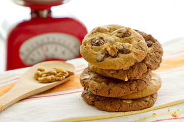 Fresh homemade gourmet cookies pile, chocolate flavour, with nuts and almonds, natural looking, resting on napkin, white clear background for breakfast, dessert, recipe