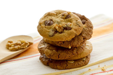 Fresh homemade gourmet cookies pile, chocolate flavour, with nuts and almonds, natural looking, resting on napkin, white clear background for breakfast, dessert, recipe
