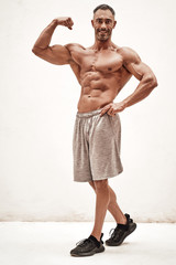 Fototapeta premium Embossed fitness couch showing his muscles looking powerful