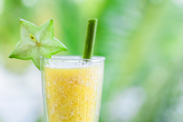 Cocktail of fresh fruit on the background of green palm leaves. Eco-friendly cocktail service.