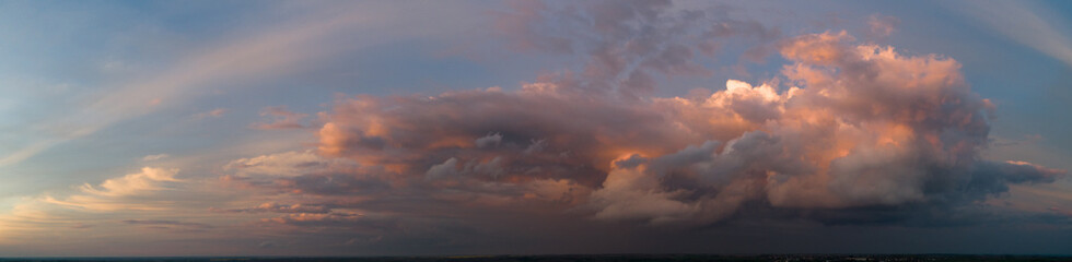 The stormy clouds on sunset panorama