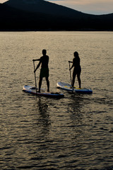 Sup boarding couple on sunset