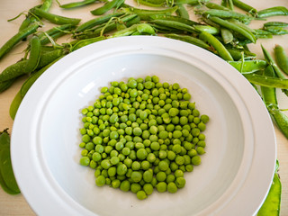 Green peas on a plate with pods