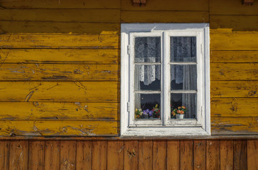Traditional old white window in a wooden house in Poland