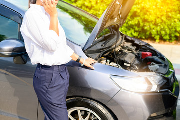 Business women use mobile phones to call for help due to broken cars