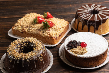 Various cakes on wooden background or table. Assortment of cakes for celebrations.