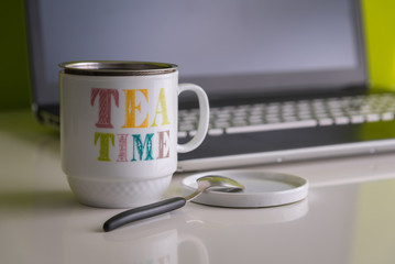 Relaxing tea time working remotely at home with a laptop in the background