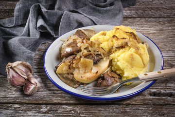 Fried liver with onion and apple, served with boiled potatoes and pickled cucumber.