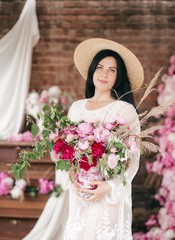Fototapeta premium Portrait of beautiful brunette woman in pink dress with pink and white pi-mesons