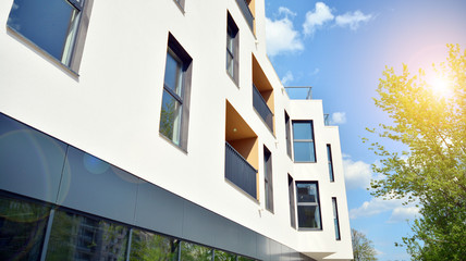 Modern apartment buildings on a sunny day with a blue sky. Facade of a modern apartment building. Glass surface with sunlight.