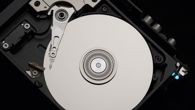 Macro, Close-Up of Computer Hard Disk Drive Spinning and Writing. Blue Lights Blinking. Slow Motion.