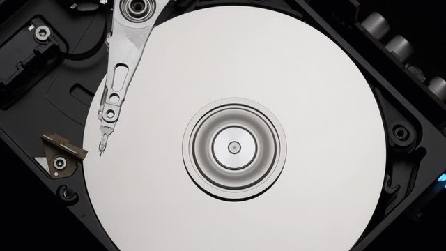 Macro, Close-Up of Computer Hard Disk Drive Spinning and Writing. Blue Lights Blinking. Slow Motion.