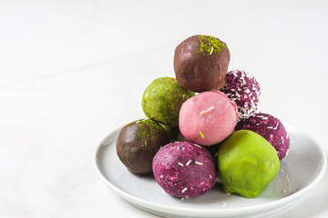 Raw vegan homemade dessert. energy balls and bites in colorful chocolate glzae . Healthy vegan snacks