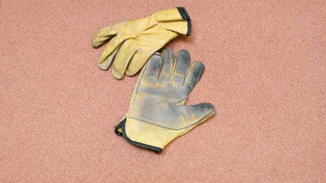 Security Gloves being tossed over a cork surface