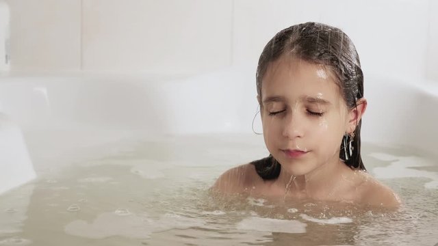 A girl washes her head under a shower, 4K UHD still video camera, 2x slow motion.