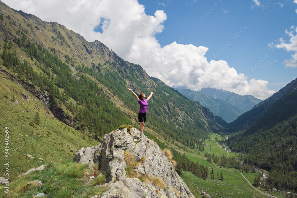 Wall mural woman standing on the top of mountain in italian alps. gran paradiso national park. italy