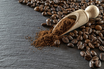 Dark coffee beans on black caffeine breakfast background. For cup of espresso food or drink. Morning energy concept and cheerfulness or evening refreshment. Macro photography, soft focus