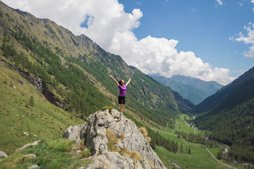 woman standing on the top of mountain in italian Alps. Gran Paradiso National Park. Italy