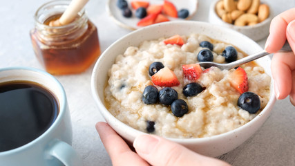 Oatmeal porridge with berries and honey. Healthy breakfast food. Eating healthy breakfast porridge oats