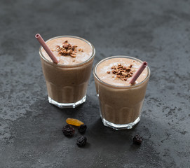 Smoothies from dried fruits and nuts in a glass with a bamboo tube on a dark gray background