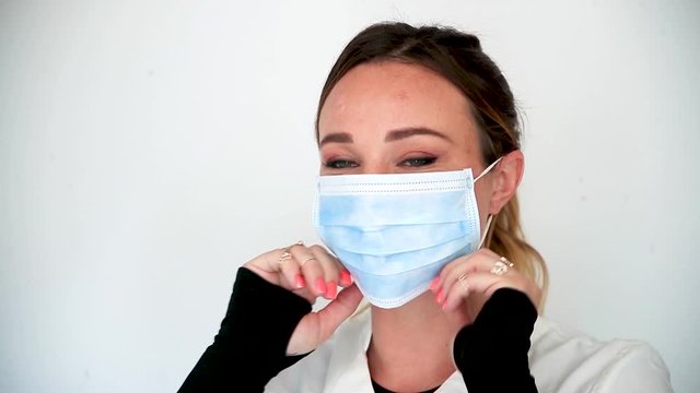 Jeune femme mettant un masque pour se prot&eacute;ger des virus