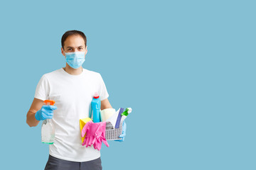 man doing apartment cleaning. Infection prevention and control of epidemic. Protective gloves and mask. blue background