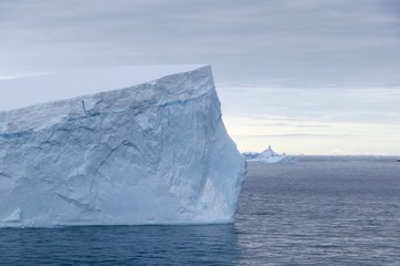 Fototapeta na wymiar Iceberg in antarctic ocean with stormy sky, Antarctica