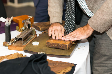 the moment of making an extra class cigar with the help of traditional Cuban production tools.