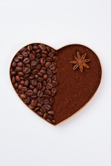 Decorative heart from coffee beans and instant coffee. Isolated on white background.