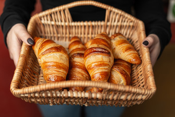 A full basket with croissants in hand.