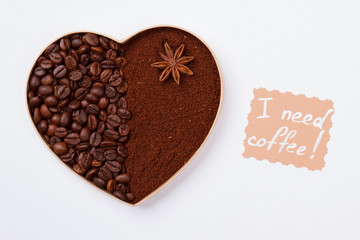 Coffee heart made of beans and instant coffee powder. Isolated on white background. I need coffee.
