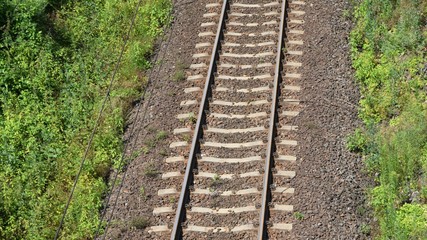 Tory kolejowe na kamiennyn nasypie pośród zielonej trawy © Jacek