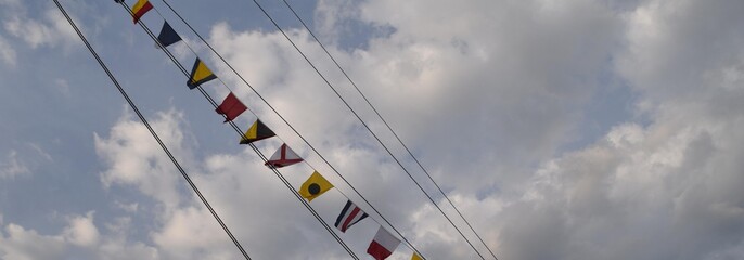 Flagi wiszące na wancie na żaglowcu - obrazy, fototapety, plakaty