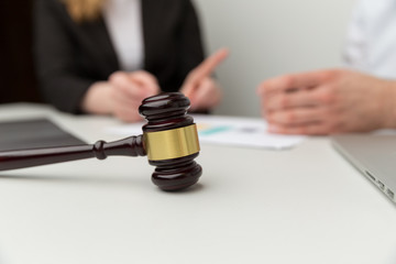 Legal support concept. People sitting at the desk with wooden hammer on it