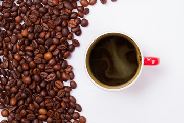 Top view roasted coffee beans and cup of coffee. White isolated background.